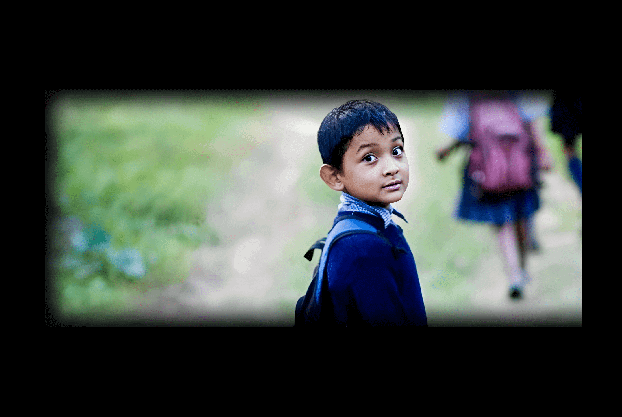 Young boy with backpack walking to school.