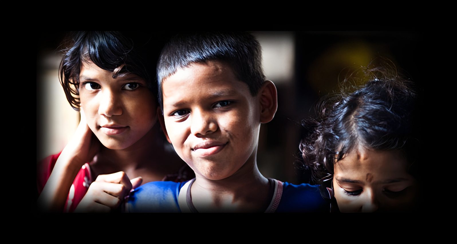 Three children posing for the camera.