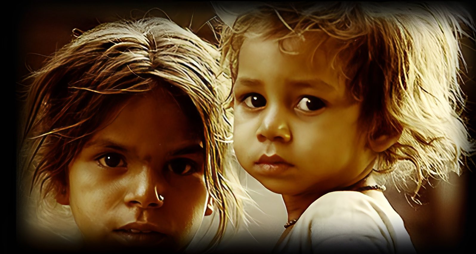 Young children with serious expressions, close-up.
